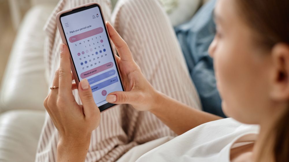 Woman tracking menstrual cycle on smartphone